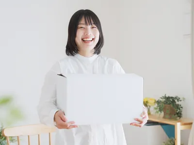 ノートパソコンを持つ笑顔の女性。EC運営者・ビジネスパーソンのイメージ