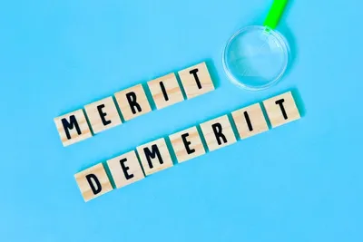 「MERIT」「DEMERIT」の木製タイルと拡大鏡で、メリット・デメリット比較