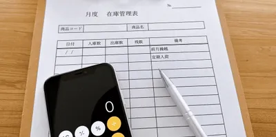 在庫管理表と計算機、ペン