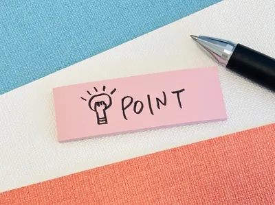 カラフル布地上に「POINT」と記された付箋紙とペン。販売ポイント記録のイメージ