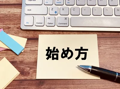キーボード上に「始め方」と書かれた紙とペン。システム導入・利用開始の手順を示唆。