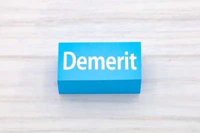 青い立体ボックスに白文字で「Demerit」と表記。課題・デメリットを視覚的に表現。
