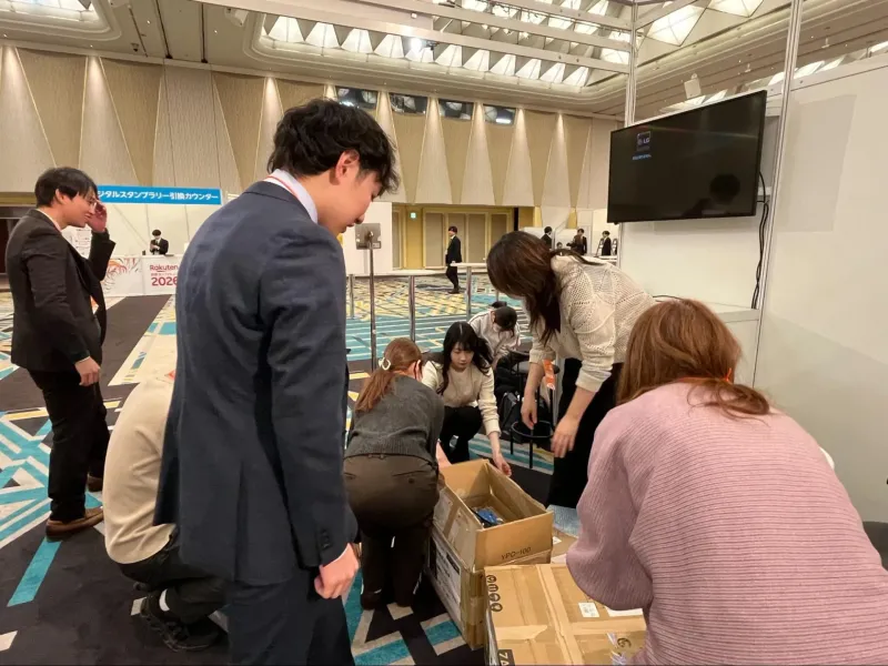 イベント終了後、スタッフ全員で段ボールから備品をしまい、チーム一丸となって片づけをしている様子
