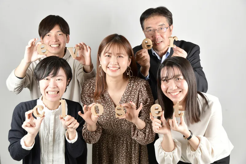 「ever closet」のアルファベットの木製オブジェを手に持ち、笑顔で並ぶ5人のスタッフの集合写真。