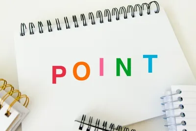 スパイラルノートにカラフルなPOINTの文字、周囲に筆記具が配置