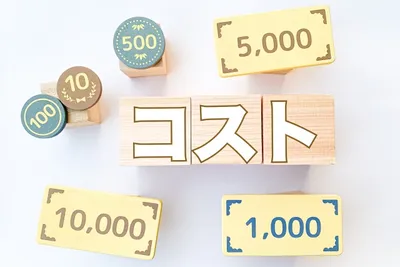 配送代行のコスト（100〜10,000）を表す数字ブロックと木製サイン