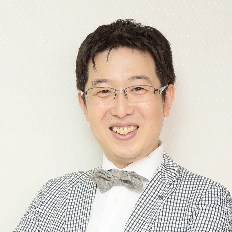 眼鏡とボウタイ、チェック柄ジャケットを身に着けたビジネスマンのポートレート写真