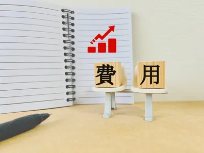 上昇するグラフと「費用」の文字ブロック。コスト増加と予算管理のイメージ