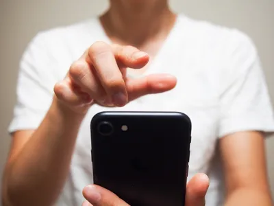 詐欺的な不正注文リスクを示唆：スマートフォンを操作する手のイメージ