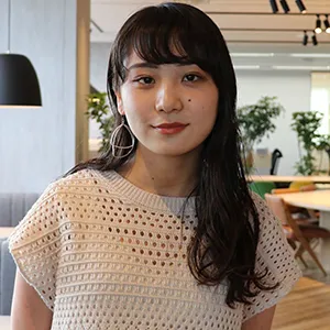 オフィス窓際に立つ女性のプロフィール写真