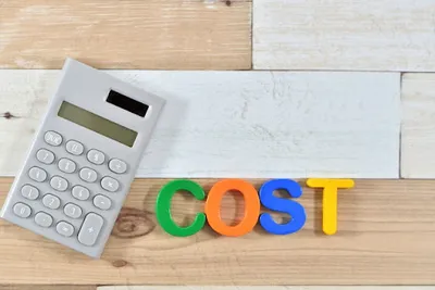 電卓とマルチカラーのCOSTテキストで営業代行導入による費用削減メリットを表現